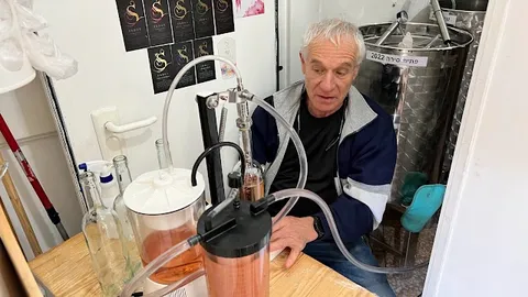היינן ליד מערכת הסינון ומכל הנירוסטה במהלך הכנת הרוזה ביקב